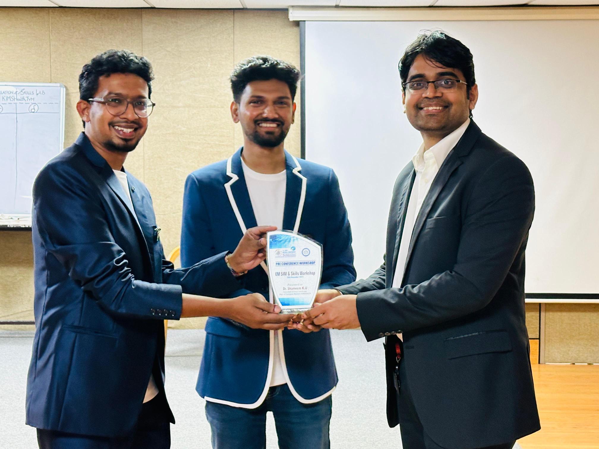 Doctor receiving a recognition plaque at the EM SIM and Skills Workshop
